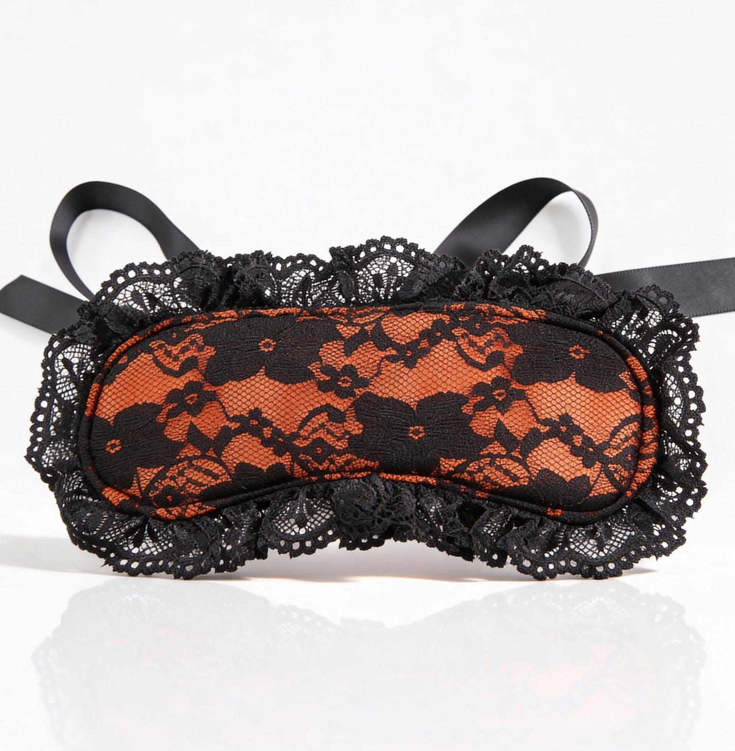 Black lace eye mask with red pattern on a white background